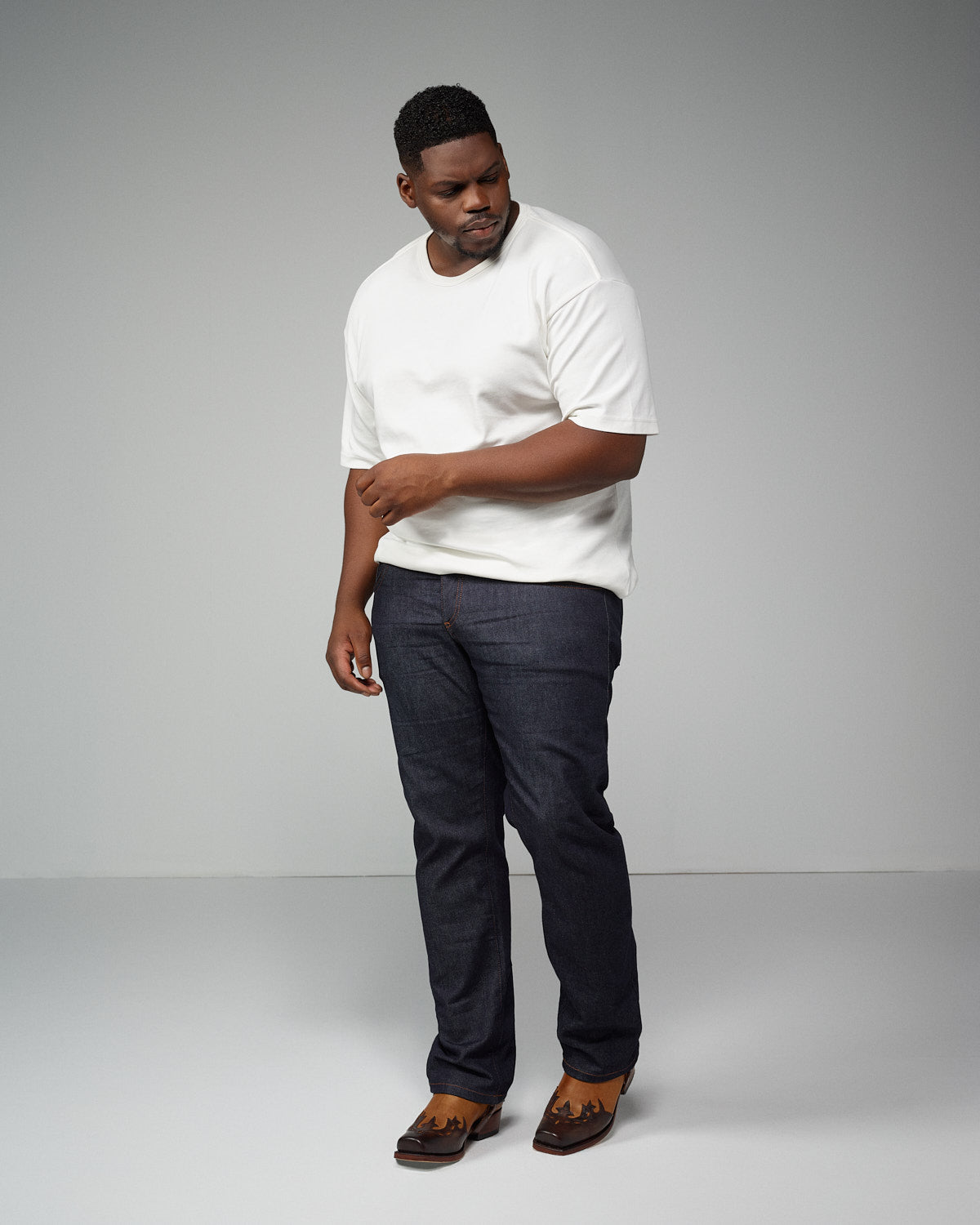 Hombre de talla grande con camiseta blanca y vaqueros oscuros
